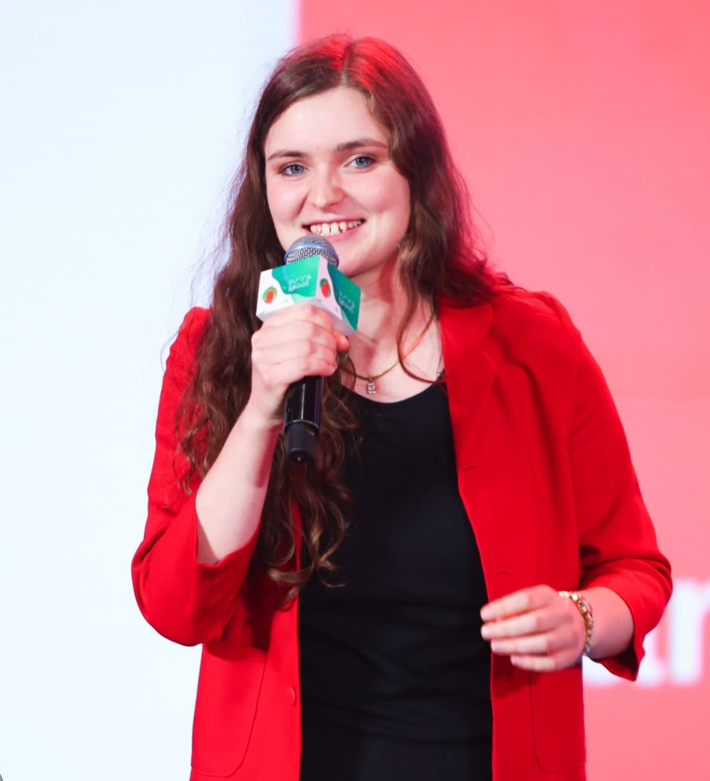 Sarah Mayrhofer bei einem Vortrag auf der Bühne mit Mikrofon